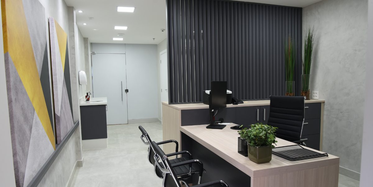 Consultório médico da Clínica Park Sul com mesa, cadeiras e pia